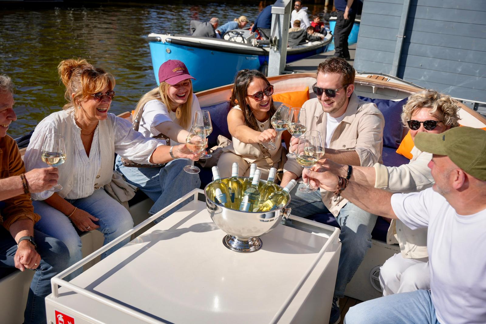 Proostende gasten aan boord van de drankjesboot in Breda met Ervaar Breda tijdens een gezellige rondvaart over de singels van Breda.